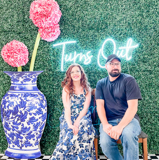 Boxwood and blue and white vase background with pink flowers and neon light custom event decor