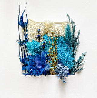 Arrangement of blue and green dried flowers on a white background fried floral persevered botanical art artwork erin elizabeth curved leaf unique gardening gifts and decor handmade small business