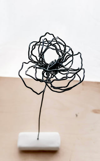 A cluster of three silver wire flowers with intricate, openwork petals. The stems are long and slender, and the flowers are arranged in a bouquet. The background is a solid, dark blue. carnation January birth flower preserved florals Mother’s Day gifts gift for mom silver and black wire flowers delicate pretty decor wedding floral preservation forver flowers wire flower stem carnations curved leaf handmade small business steel aluminum petals dried florals whimsical decor